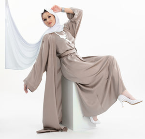 Three-piece silk Abaya set crafted from premium silk fabric, showcasing a captivating textured lines pattern. Includes a flowing gown, matching liner, and coordinating belt | Beige