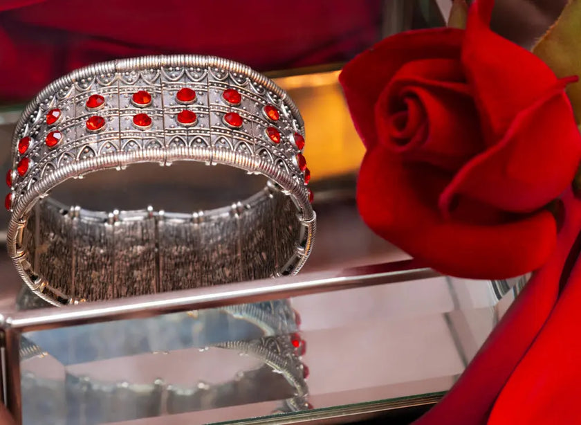 Silver hand cuff with red stones and elastic flexibility, adding sophistication and glamour to any outfit.