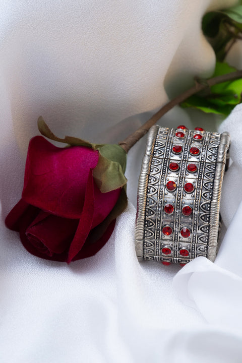 Silver hand cuff with red stones and elastic flexibility, adding sophistication and glamour to any outfit.