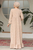 Muslim woman wearing a beige embroidered cotton maxi dress with ruffle hem and long sleeves, modest and breathable for casual or formal wear.