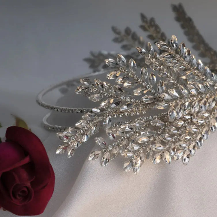 Elegant silver crystal bridal hairpiece featuring a leaf design with sparkling rhinestones. A perfect wedding headpiece for brides and formal occasions.