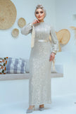 A woman wearing a modest silver sequin maxi gown with a satin waist belt, perfect for formal events and Eid – Zari Hijabeez