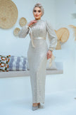 A woman wearing a modest silver sequin maxi gown with a satin waist belt, perfect for formal events and Eid – Zari Hijabeez